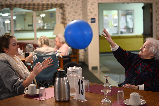 Karianne Johnsen, junior advertising major, tosses a balloon with Mary Nicolino, a 98-year-old resident of Stow-Glen Retirement Home, during the Martin Luther King Jr. Just 4 A Day event put on by Kent State Hillel Monday, Jan. 20, 2014. It is a common exercise between the facilitys residents.