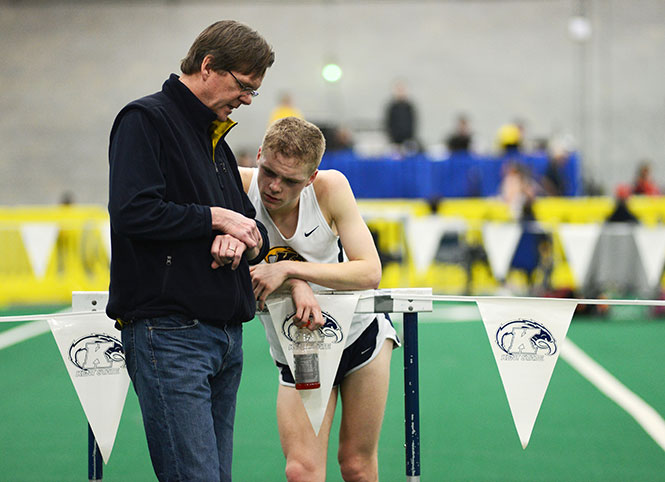 Sophomore Conor Whelan discusses his race time with his father after running the 5000 metres race at the dual-open Doug Raymond Invitational at the Field House, Saturday, Jan. 11, 2014.