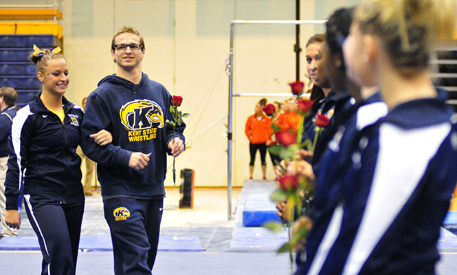 Senior T.J. Keklak (right) enters with senior Marie Case (left) at the Beauty and the Beast gymnastics and wrestling meet on Feb. 8, 2013.