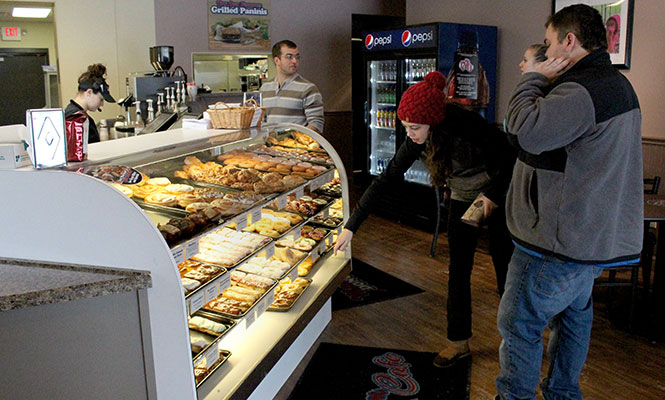 Aaron Frazee, Maddy Jordan and Jenny Stamberger (from left) decide on their donut selections while worker Brittany Tosatto cashes out Kevin Taylor at Mary Ann Donuts on Sunday, Feb. 9, 2014.