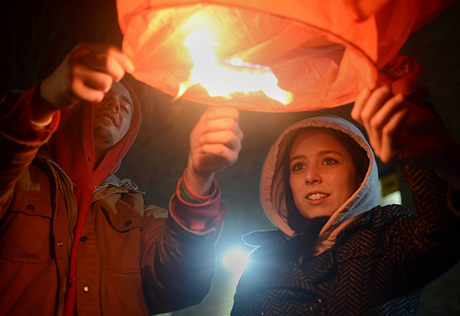 Abigail Yates (right), a 16-year-old junior at Chardon High School, and Nate Mueller (left), an 18-year-old graduate of Chardon High School, burn a paper lantern to honor the second anniversary service for the shooting that claimed three lives.