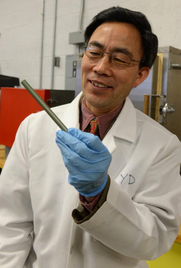 Professor Yanhai Du holds a fuel cell in the Van Duesen Hall lab on Monday, Feb. 10, 2014. Du hopes to promote fuel stem cell research to help teach students technology in a more energy efficient way as fuel cells dont use Hydrogen.