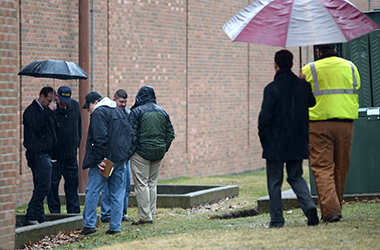 Kent State employees examine a sinkhole that opened up in an area between the student center and M.A.C. Center, caused by a waterline break. As a result, power was lost in the Student Center, M.A.C. Center, and M.A.C.C. Annex, Wednesday morning, March 12, 2014. All three were closed Wednesday due to the power loss, and as a safety precaution.