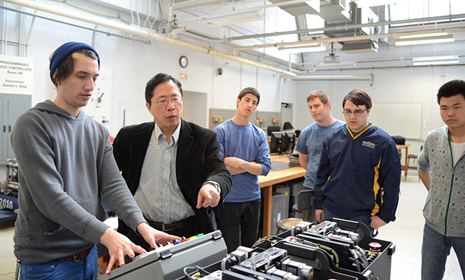 Senior industrial technology major Dan Kish (left) demonstrates motion control to Professor Shin-Min Song and members of the new robotics club at Kent State University in Van Deusen Hall Friday, April 11, 2014.