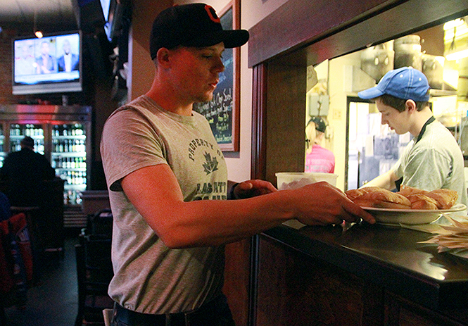 A waiter serves food to hungry customers at Rays Place, April 8, 2014.