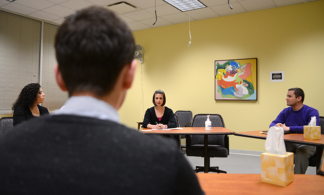 (From left) Hearing officer Lucy Omar, hearing officer and convener Lisa Oddo and residence hall director John Hummell share introductions with a student before beginning a hearing panel in the office of student conduct, located in Beall/McDowell Hall, early Tuesday, April 15, 2014.