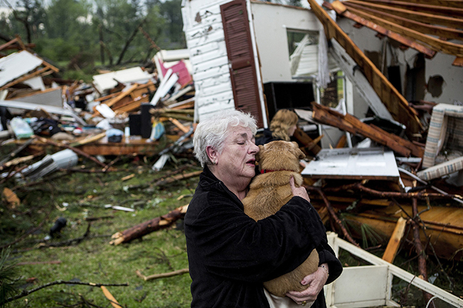 Constance Lambert embraces her dog after finding it alive when returning to her destroyed home in Tupelo, Miss., on Monday, April 28, 2014. Lambert was at an event away from her home when the tornado struck and rushed back to check on her pets. (Brad Vest/The Commercial Appeal/MCT)