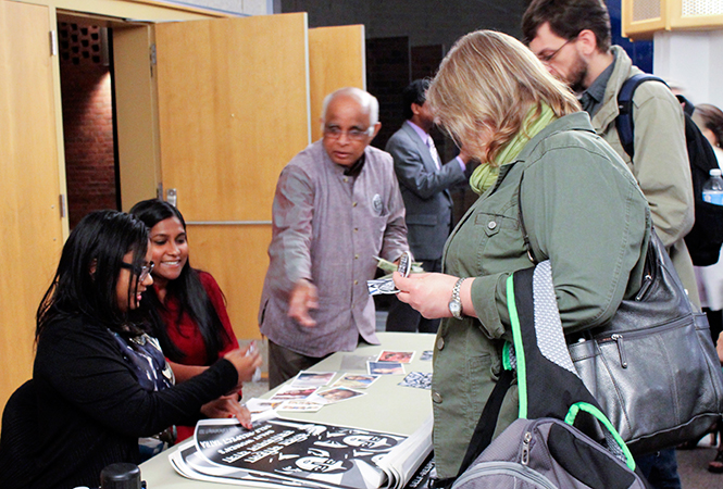 Asha Kowtal and Thenmozhi Soundararajan sign posters after their presentation on the issues of sexual violence toward the Dalit (untouchable) caste of India at Kent State-Stark, Thursday, Apr.10, 2014. They sell the posters as part of their fundraising methods.