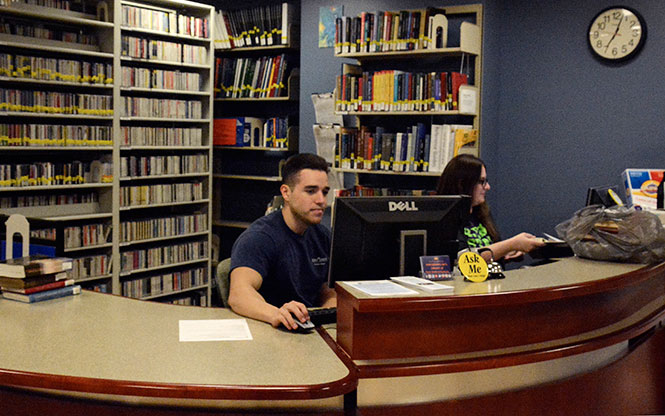 Patrick Markovich (left) and Sarah Holmes (right) work at the Performing Arts Library Tuesday, April 29, 2014. Markovich has been working at the library for the past year and Holmes has been a part of the team for eight months. The two are available at the desk to help answer any questions regarding the library.