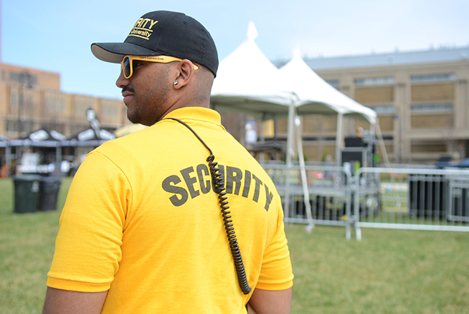 Julian Johnson, a Kent State Security guard, waits near the stage before the Flashfest concert starts, Thursday, April 24, 2014. Guards are each given a radio in case they need to make a call to police.
