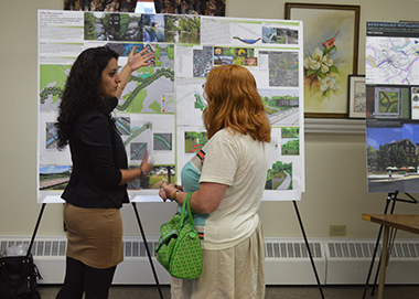 Kent State graduate architecture student Parva Majidi presents her design, titled Creek Revitalization, to a resident of Garrettsville, Ohio at an open meeting held Friday, July 25 in the village city hall.