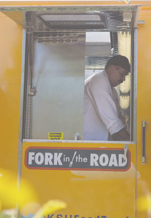 Executive Chef Christian Booher prepares meals for the new food truck on campus Monday, August 25, 2014. Fork in the Road aims to bring lunch options to areas of campus where students don’t have many eatery options.