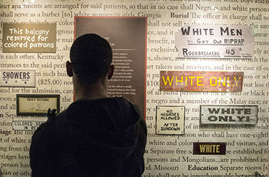 Kenny Jenkins, a communication Studies major, stops to look at a wall in the Jim Crow Museum of Racist Memorabilia that shows just a small sample of the thousands of Segregation laws from the Jim Crow Era on Friday, Sept 19, 2014. The list of laws was compiled by the Martin Luther King Jr. National Historic site interpretive staff.
