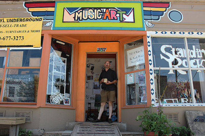 Executive Director of Standing Rock Cultural Arts, Jeff Ingram, stands in the doorway with a coffee mug at the North Water Street Gallery located on 257 N. Water St. on August 29, 2014.