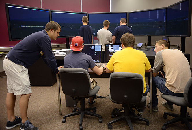 Dan Hines, Senior Air Traffic Control major (left), helps Freshman Air Traffic Control and Flight Tech majors use open lab time to brush up on their skills using the ATC simulator programs Tuesday, Sept. 9, 2014.