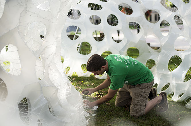 Kent State alumnus Adam Hirsh helps to assemble a sculpture on front campus Sunday, Sept 28, 2014, that was designed and created by architecture students as part of the MATr Project. This specific sculpture is compiled of 1,300 panels held together with 40,000 zipties.