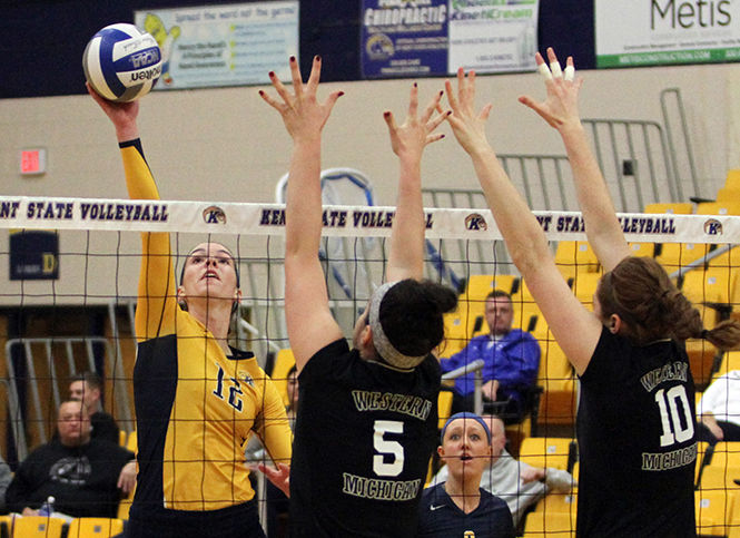 Kent State junior middle blocker Bridget Wilhelm hits the ball around the block during a game against Western Michigan on Saturday, Oct. 25, 2014. The Flashes won, 3-1.