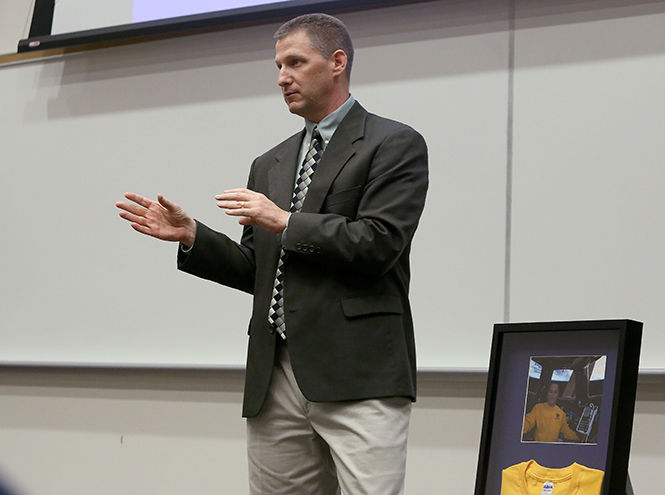 Bruce Nieschwitz, Kent State athletic training alumnus and current NASA employee, presents the athletic deaprtment with a Kent State t-shirt that was given to an astronaut to wear in space at a reception Thursday, Oct. 2, 2014.