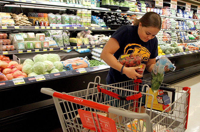 Junior exercise science major Clare Heisey shops for her weekly groceries at Marc’s in Kent during its grand opening Wednesday, Oct. 1, 2014.