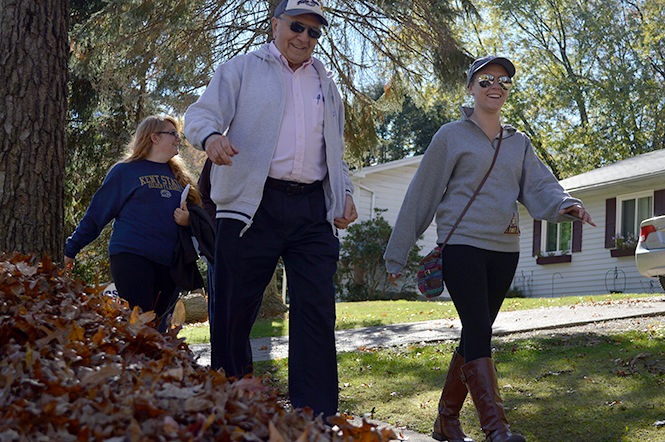 Jerry Feezel, who helped organize the Walk For The Children, shares a laugh with participant Chelsea Hillard as they march through a neighborhood on their way to downtown Kent on Sunday, Oct. 26 2014. The Walk For The Children event, hosted by LoveLight, Inc. and Delta Omicron, was held to raise money to support programs that promote the healthy development of children.