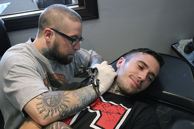 Tattoo artist Justin Evans tattoos Lee Vojack at Smokin Tattooz, located at 100 E. Main St. Ohio recently passed new regulations regarding the cleanliness and sanitation of tattoo parlors that will be enforced by the Department of Health.  