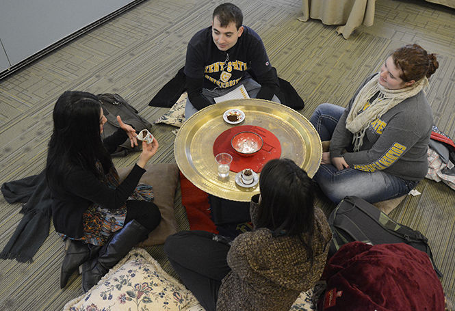 Ece Gogebakan reads the fortunes for a group of students by looking at the shapes and figures made by the leftover grounds of Turkish coffee at the Turkish fortune-telling event in White Hall on Thursday, Nov. 20, 2014.