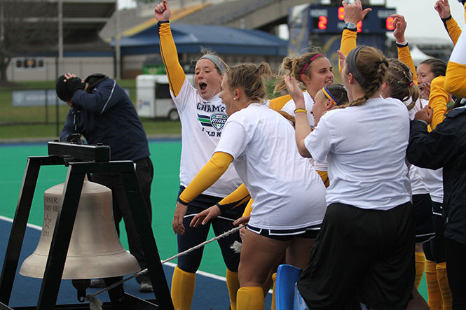Kent State teammates ring the victory bell after beating Ohio University in the MAC championship game Saturday, November 8, 2014. The Flashes won, 2-0.