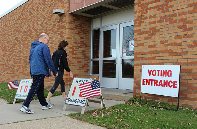 Kent residents John Ferlito and Linda Ferlito walk into the voting entrance at Theodore Roosevelt High School on Election Day, Nov. 4, 2014.