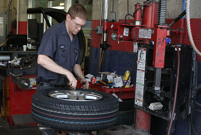 A+mechanic+works+on+a+tire+in+a+mechanic+shop+in+Kent%2C+October+27%2C+2014.