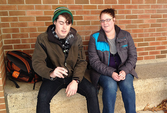 Junior environmental conservation biology major Sean Nichols and junior German/French translation major Kyle Darrah smoke outside the Student Center on Friday, Nov. 21, 2014. Nichols said Kent State becoming smoke-free could potentially help him quit smoking, while Darrah said she thinks enforcing the policy would distract campus security from more pressing issues.