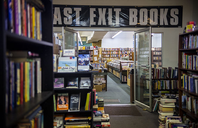 Jason+Merlene%2C+owner+of+Last+Exit+Books%2C+stocks+records+during+a+slow+shift+at+Last+Exit+Books+on+Tuesday%2C+Dec.+2%2C+2014.+Last+Exit+Books+is+located+on+E.+Main+Street+in+Downtown+Kent.