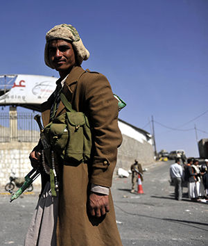 A Houthi fighter stands outside a presidential guard barrack overlooking the presidential palace on Wednesday, Jan. 21, 2015, one day after clashes erupted between presidential guards and Shiite Houthi fighters.