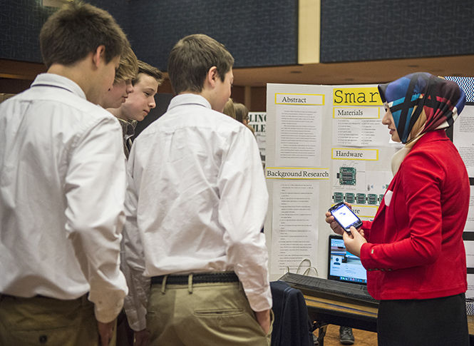  Zeynep Ozgur, 16, explains to a group of her classmates how her smartphone can be used to transfer messages to an LED light board during the STEM Science Fair event in the Kent State Ballroom on Saturday, Jan. 24, 2015.