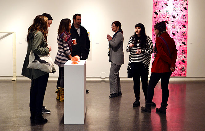 Students and professors gather around the School of Art Gallery during the graduate student biennial reception on Thursday, Jan. 15, 2015. The gallery features works of art from graduate students in the School of Art.