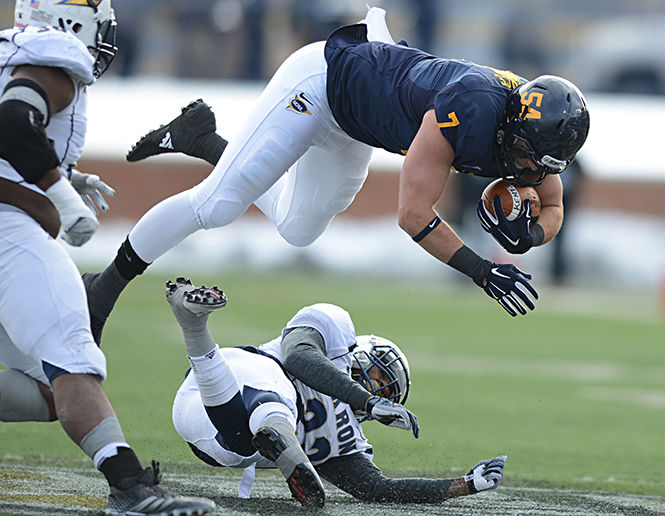 Casey Pierce leaps over Akrons Martel Durant at the Wagon Wheel game on Friday, Nov. 28, 2014 at Dix Stadium.