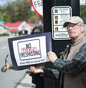 David Stover, a resident of Tallmadge, holds his Issue 21 sign out to the passing traffic on E. Main with other demonstrators from the Global Frackdown rally Saturday, Oct. 11, 2014. Issue 2, on the Nov. 4 ballot, could create a community bill of rights for the city of Kent that would allow the community to have more of a say in the creation and location of fracking and drilling.