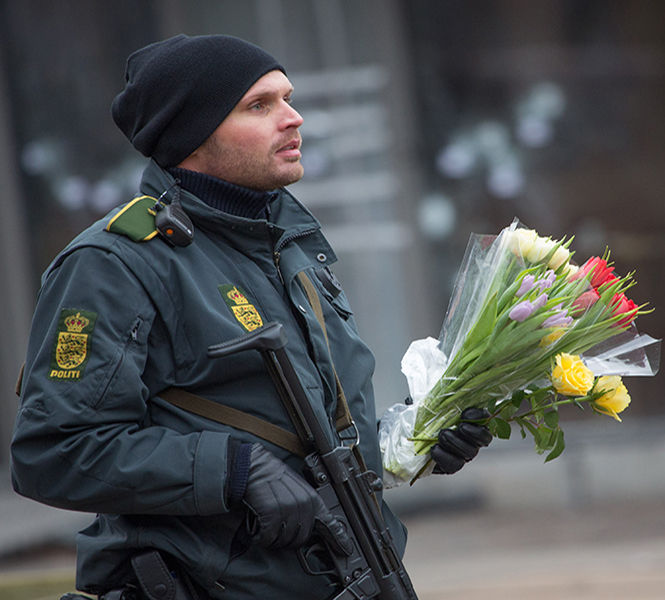 A policeman brings flowers to the scene of Saturdays terror attacks in Copenhagen, Denmark, on Sunday, Feb. 15, 2015. Police in Copenhagen say they have shot dead a man they believe was behind two deadly attacks in the Danish capital hours earlier. It came after one person was killed and three police officers injured at a free speech debate in a cafe on Saturday. In the second attack, a Jewish man was killed and two police officers wounded near the citys main synagogue. (Bjorn Kietzmann/Action Press/Zuma Press/TNS)