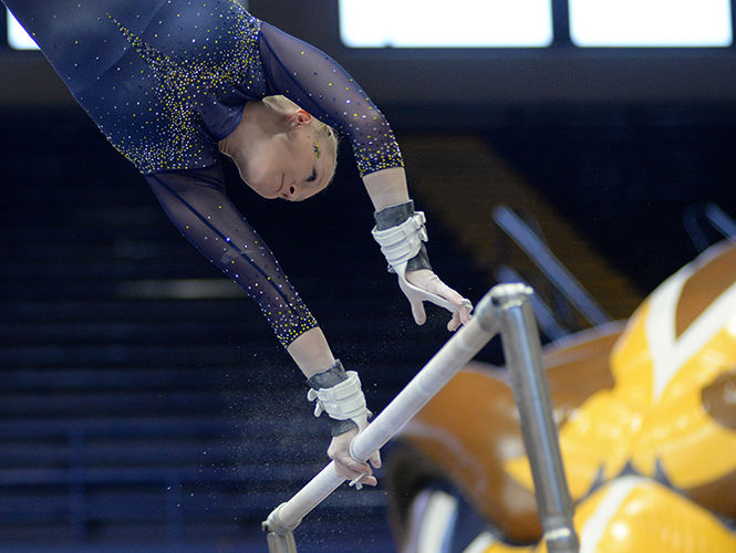  Kent State’s Whitnee Johnson competes on the uneven bars during the meet against Central Michigan University on Sunday, Feb. 15, 2014. Johnson finished her routine with a 9.725 and the Flashes lost with an overall score of 195.325-196.400.