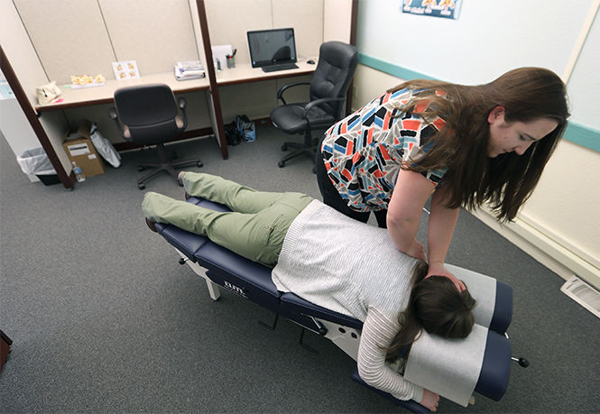 The Kent Stater Dr. Amber Aiken works on a patient at the University Chiropractic and Wellness Center in Kent. The center opened in January and services the university and surrounding communities. Monday, Feb. 9, 2015.
