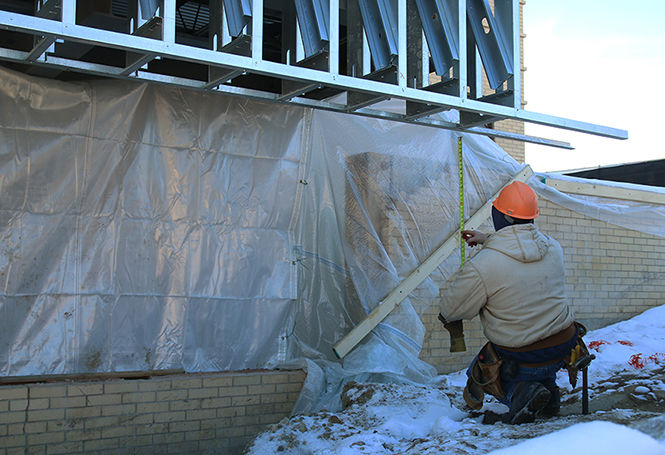  A construction worker for Canton Floors Inc. measures a beam outside of the Art Annex on Wednesday Jan. 28, 2015. Construction on the art building is set to be complete in early June.