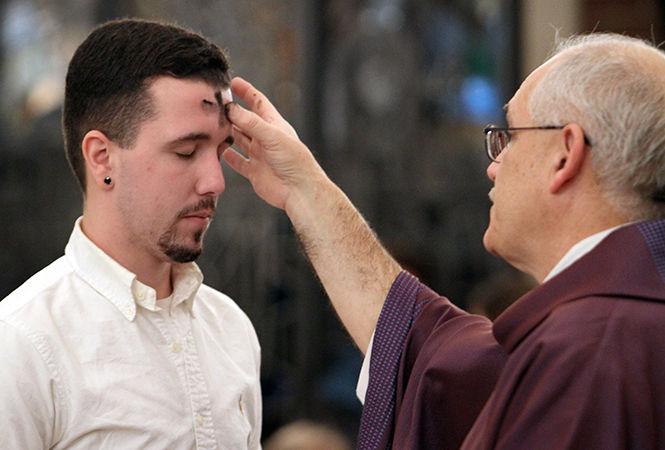 Junior+aeronautics+major+Taylor+Robinson+receives+ashes+on+his+forehead+from+Fr.+Steven+Agostino+during+the+evening+Ash+Wednesday+mass+at+the+Newman+Center+on+Wednesday%2C+Feb.+18%2C+2015.