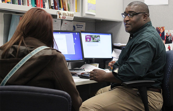 Academic Advisor H. Bate Agbor-Baiyee discusses scheduling with a student during an advising appointment on the 5th floor of the Kent State Library on Nov. 13, 2014.