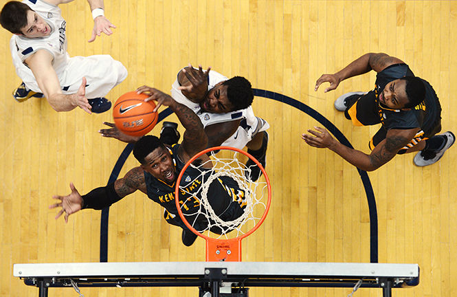 Kent State red shirt senior guard Derek Jackson (center)  takes a shot, under defense from University of Akron sophomore center Isaiah Johnson at the James A. Rhodes Arena in Akron, Ohio, Tuesday, February 10, 2015. Kent lost to Akron, 61-52.