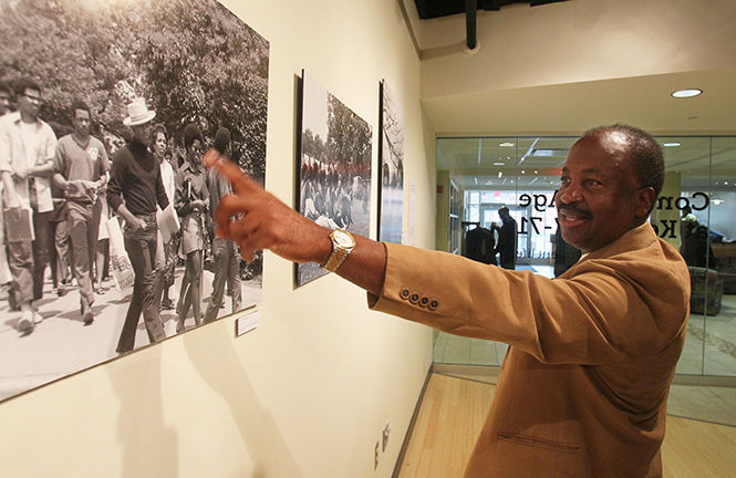 Lafayette Tolliver, a Kent State Univeristy alumus 1967-71 points out an old friend in one of the photos in an exhibit of his photographs called, Coming of Age at Kent 1967-71 A pictorial of Black Student Life in the Uumbaji Gallery in Oscar Ritchie Hall on Saturday Oct. 18, 2014 in Kent, Ohio. Tolliver worked as a photographer for the Daily Kent Stater and Chestnut Burr student year book during his time at the university. (Mike Cardew/Akron Beacon Journal)