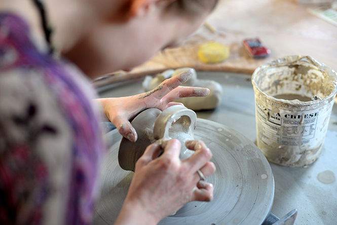Carys Bobbitt, junior Art Education major, makes a handle to fit to her cup in the ceramics studio on Tuesday, March 3, 2015.