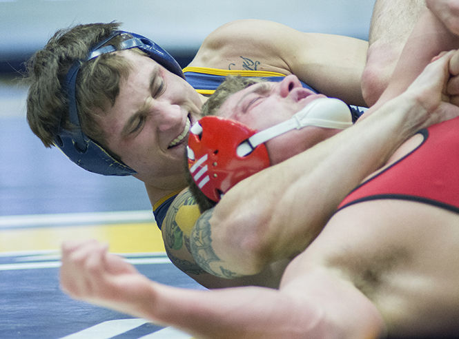 Kent State University Senior Caleb Marsh tries to pin Northern Illinois Universitys Trace Engelkes during Kents final home match of the season in the M.A.C. Center on Friday, Feb.13, 2015. March won 10-4 over Engelkes and the Flashes won 27-6 bringin their record to 8-12 overall.