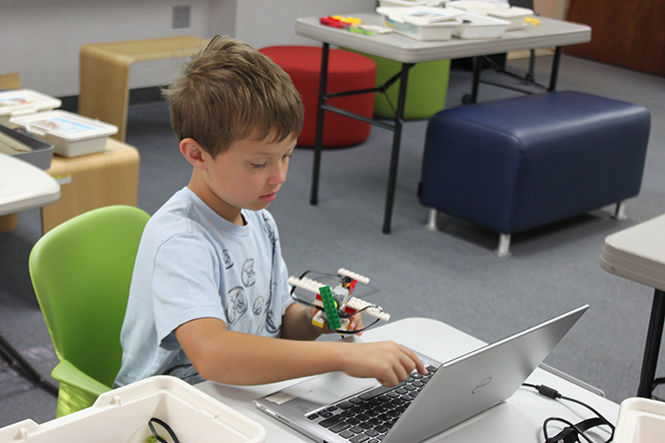 A camper builds a LEGO model during a LEGO WeDo Robotics Level 1 camp in the AT&T Classroom of Moulton Hall on Monday, July 20, 2015.