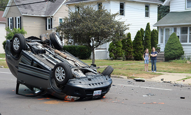 Two bystanders look at the aftermath of a two-car accident on the corner of N. Mantua and Carthage on S.R. 43 on Aug. 21, 2015.