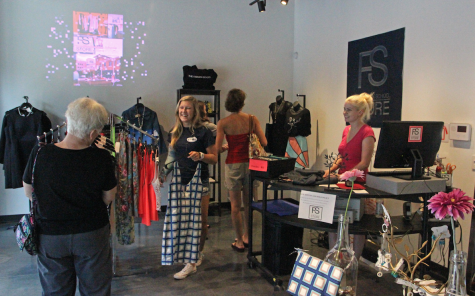 Emma Peterson (far right), a Kent State graduate student and employee at the Fashion School Store, helps customers at the store on Thursday, July 30, 2015.