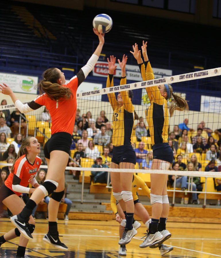 A Bowling Green outside hitter spikes the ball against two Kent State Volleyball players. The golden Flashes defeated Bowling Green 3-1 at the MACC on Saturday, Sept. 26, 2015.